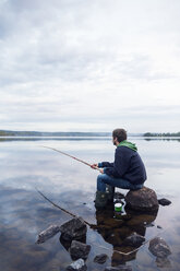 Mittelgroßer Mann beim Angeln an einem See in Dalarna, Schweden - FOLF10171