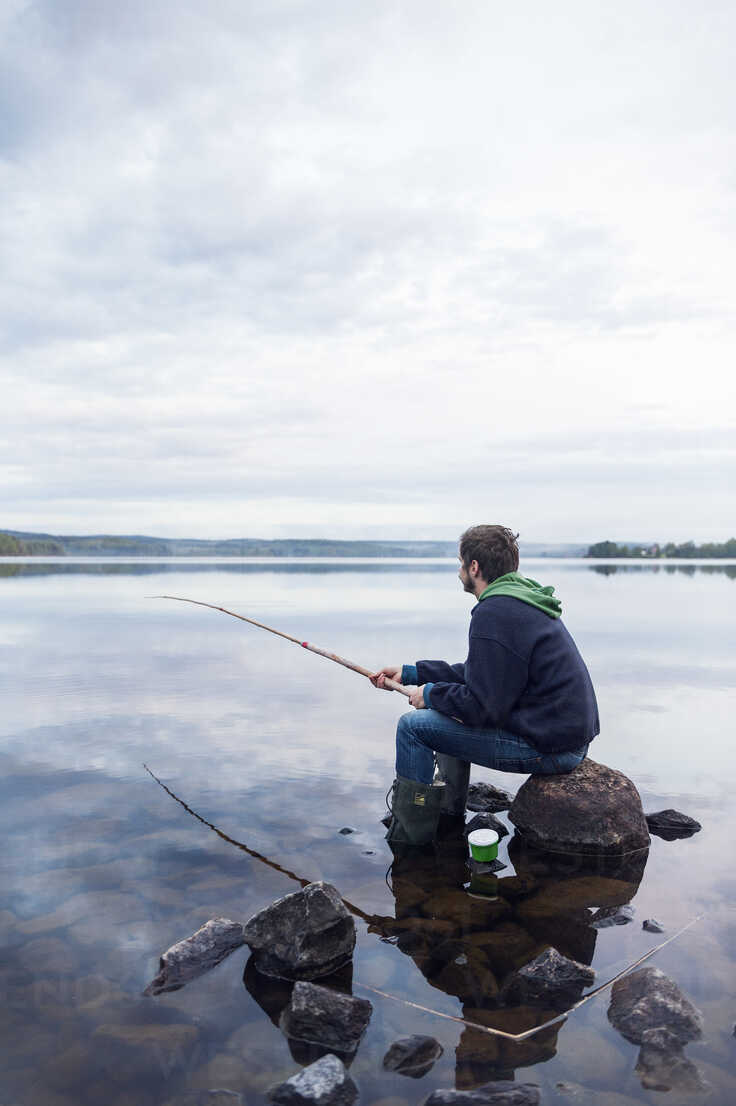 Mid adult man fishing on a lake in Dalarna, Sweden stock photo