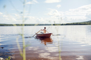 Mann rudert ein Boot auf einem See in Dalarna, Schweden - FOLF10173