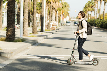 Man with backpack and E-Scooter crossing the street - VABF02060