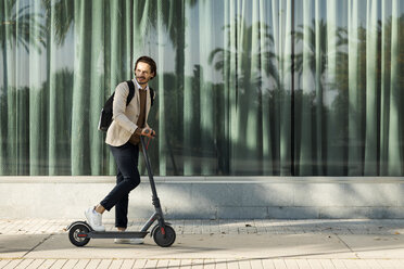 Mann mit Rucksack und E-Scooter in der Stadt - VABF02067