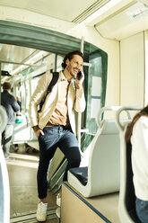 Lachender Mann am Telefon in der Straßenbahn - VABF02086