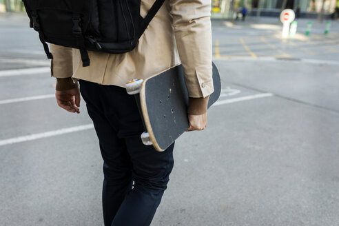 Mann mit Rucksack und Skateboard in der Stadt, Teilansicht - VABF02090