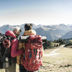 Austria, Tyrol, rear view of couple on a hiking trip in the mountains enjoying the view - UUF16342