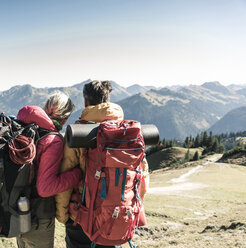 Österreich, Tirol, Rückansicht eines Paares beim Wandern in den Bergen, das die Aussicht genießt - UUF16342