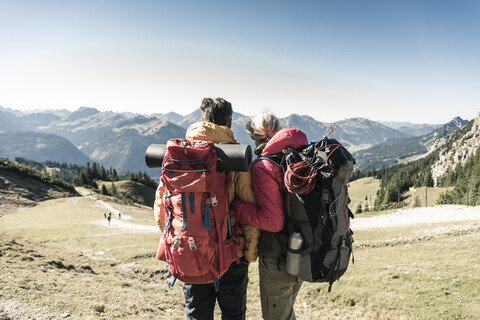 Österreich, Tirol, Rückansicht eines Paares beim Wandern in den Bergen, das die Aussicht genießt, lizenzfreies Stockfoto