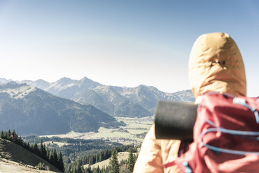 Austria, Tyrol, rear view of man on a hiking trip in the mountains enjoying the view - UUF16344