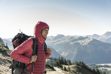 Austria, Tyrol, smiling woman on a hiking trip in the mountains enjoying the view - UUF16352