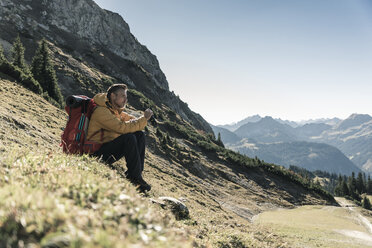 Österreich, Tirol, Mann bei einer Pause während einer Wanderung in den Bergen - UUF16355