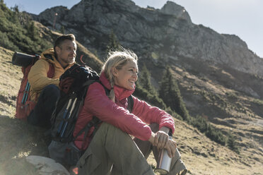 Austria, Tyrol, couple having a break during a hiking trip in the mountains - UUF16356