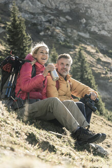 Österreich, Tirol, glückliches Paar bei einer Pause während einer Wanderung in den Bergen - UUF16357
