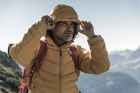 Österreich, Tirol, Porträt eines Mannes mit Kapuzenjacke auf einer Wanderung in den Bergen, lizenzfreies Stockfoto