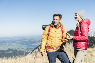 Austria, Tyrol, couple with compass hiking in the mountains - UUF16391