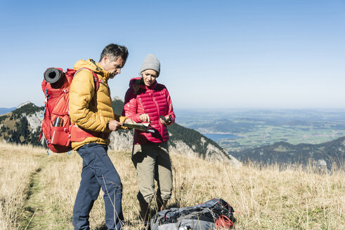 Österreich, Tirol, Paar mit Karte beim Wandern in den Bergen - UUF16392