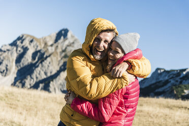 Austria, Tyrol, happy couple hugging on a hiking trip in the mountains - UUF16393