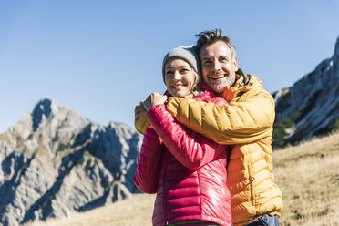 Österreich, Tirol, glückliches Paar, das sich bei einer Wanderung in den Bergen umarmt - UUF16395