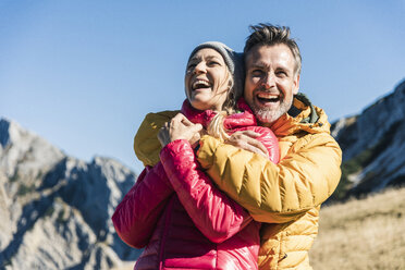 Österreich, Tirol, glückliches Paar, das sich bei einer Wanderung in den Bergen umarmt - UUF16396