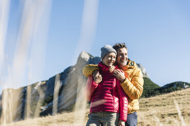 Österreich, Tirol, glückliches Paar, das sich beim Wandern in den Bergen umarmt - UUF16398