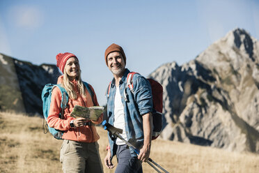 Austria, Tyrol, happy couple with map on a hiking trip in the mountains - UUF16404