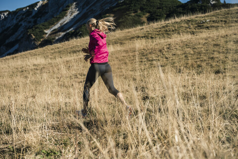 Österreich, Tirol, Frau beim Laufen in den Bergen, lizenzfreies Stockfoto