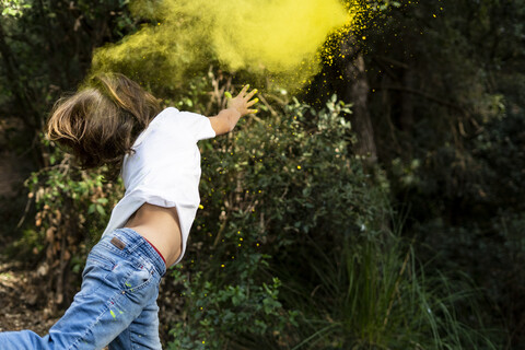 Junge wirft buntes Farbpulver, er feiert Holi, das Fest der Farben, lizenzfreies Stockfoto