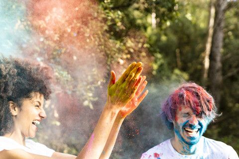 Couple throwing colorful powder paint, celebrating Holi, Festival of Colors stock photo