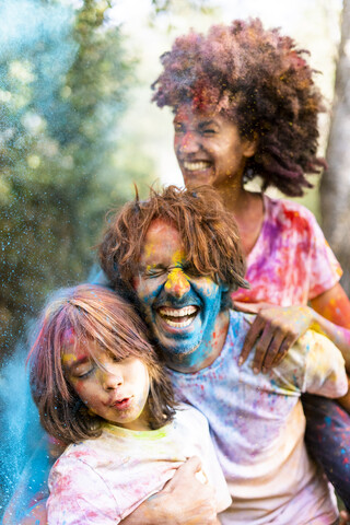 Family full of colorful powder paint, celebrating Holi, Festival of Colors stock photo