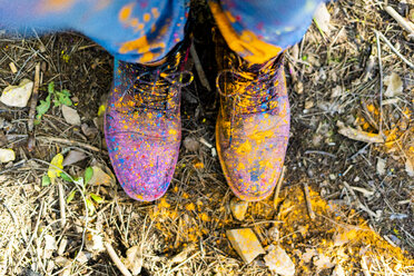 Die Schuhe einer Person, die mit Puderfarbe bedeckt ist und Holi, das Fest der Farben, feiert - ERRF00468