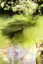 Boy shaking his head, full of colorful powder paint, celebrating Holi, Festival of Colors - ERRF00478