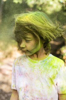 Junge schüttelt den Kopf, voll mit buntem Farbpulver, beim Feiern von Holi, dem Fest der Farben - ERRF00481