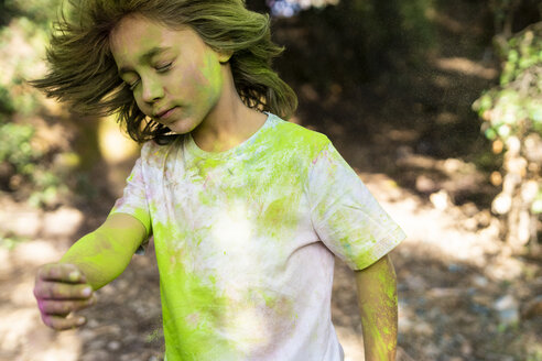 Junge schüttelt den Kopf, voll mit buntem Farbpulver, beim Feiern von Holi, dem Fest der Farben - ERRF00487