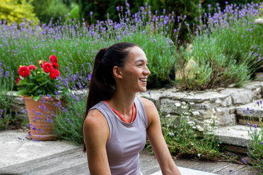 Frau übt Yoga im Garten und macht eine Pause auf der Veranda - CUF46590