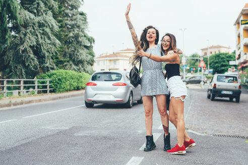 Girlfriends hailing cab in middle of road - CUF46654