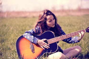 Girl playing guitar on grass - CUF46782