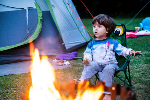 Kind entspannt sich vor einem Lagerfeuer - CUF46811