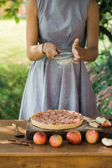 Frau bereitet Apfelkuchen auf einem Tisch vor - CUF46837