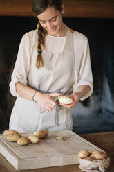 Woman peeling potatoes for gnocchi - CUF46845