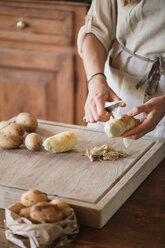 Woman peeling potatoes for gnocchi - CUF46846