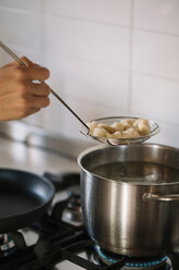 Potato gnocchi being removed from pot - CUF46852