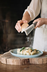 Potato gnocchi on plate being garnished - CUF46855
