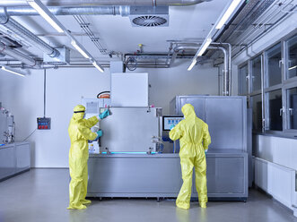Chemists working in industrial laboratory, wearing protective clothing in the clean room - CVF01092