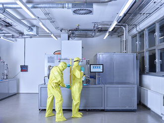 Chemists working in industrial laboratory, wearing protective clothing in the clean room - CVF01093