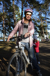 Finnland, Kuopio, Mutter und Tochter mit Fahrrad auf einem Waldweg - PSIF00203