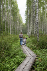 Finland, Kuopio, mother and daughter walking in a birch forest - PSIF00208