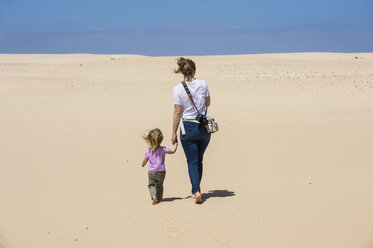 Spain, Canary Islands, Fuerteventura, Parque Natural de Corralejo, mother and daughter walking in sand dunes - RUNF00866