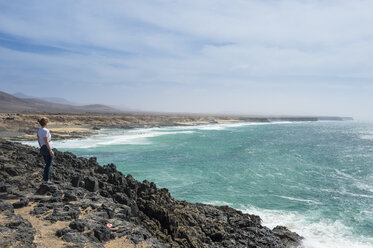 Spanien, Kanarische Inseln, Fuerteventura, Frau schaut auf den Strand von El Cotillo - RUNF00870