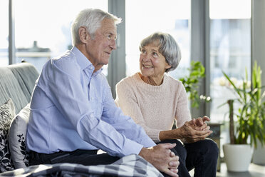 Älteres Paar sitzt auf der Couch und spricht miteinander - RBF06981