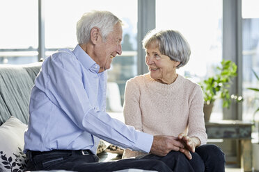 Senior couple sitting on couch talking together - RBF06982