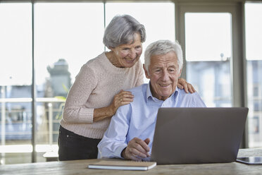 Portrait of smiling senior couple using laptop - RBF07005