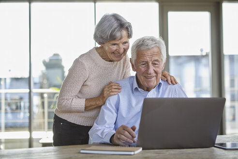 Porträt eines lächelnden älteren Paares mit Laptop - RBF07005